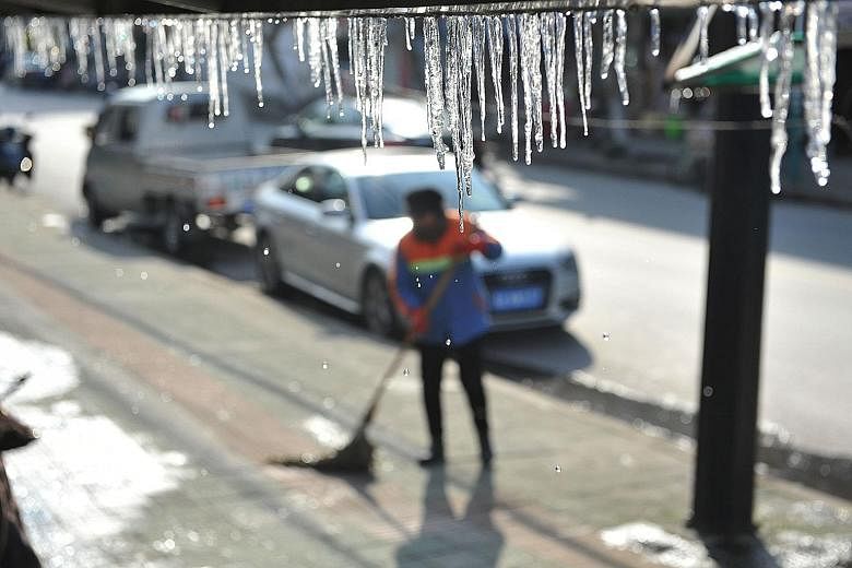 Icicles hanging from a roof in Linan in east China's Zhejiang province yesterday. Most of the country shivered as a teeth-chattering cold snap broke decades-old records and snow fell in some areas for the first time in years.