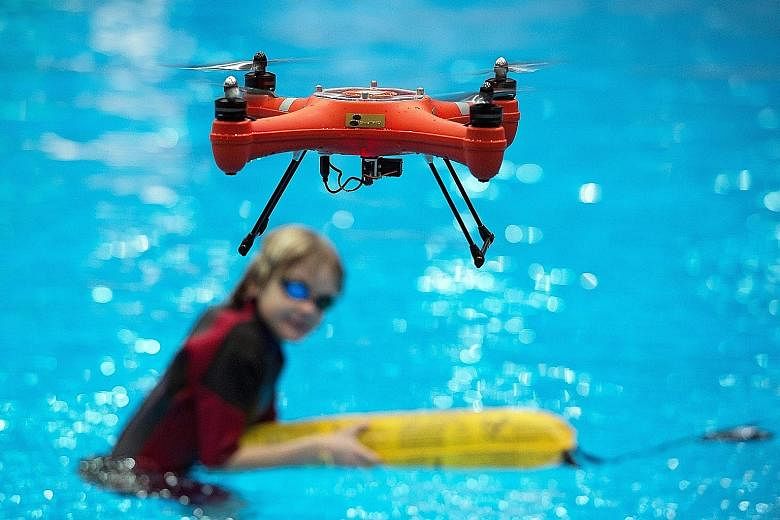 A waterproof Splash drone hovering in mid-air after dropping a rescue package for a child in a pool during its press debut at the water sports event Boot in Duesseldorf, Germany. Boot is the world's largest trade fair for the industry, covering saili