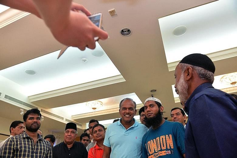 Mr Shanmugam (centre) at a thank-you lunch for several Bangladeshi construction workers at Khadijah Mosque yesterday. Addressing their worry about how the arrests of their countrymen would affect them, he said: "I assured them, just stick to what you