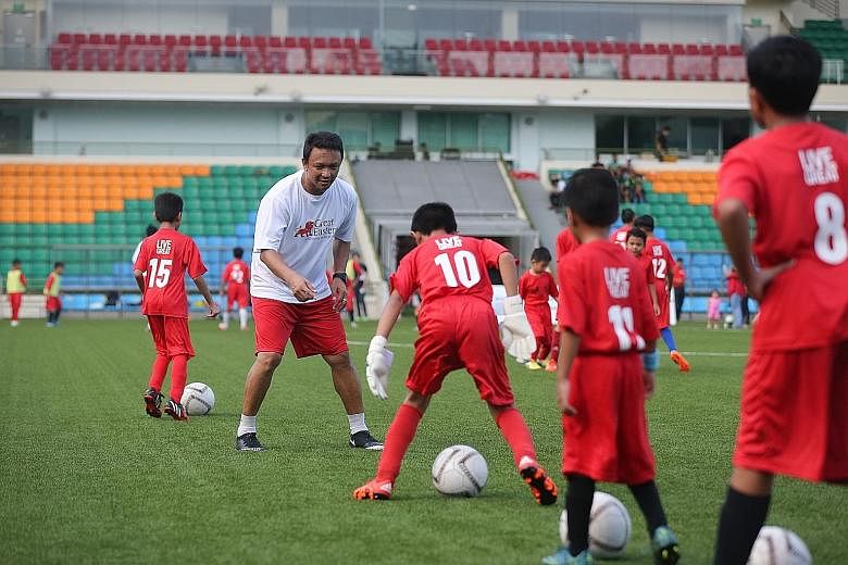Local football great Fandi Ahmad and other former Lions teaching the youngsters the finer points of dribbling and passing.