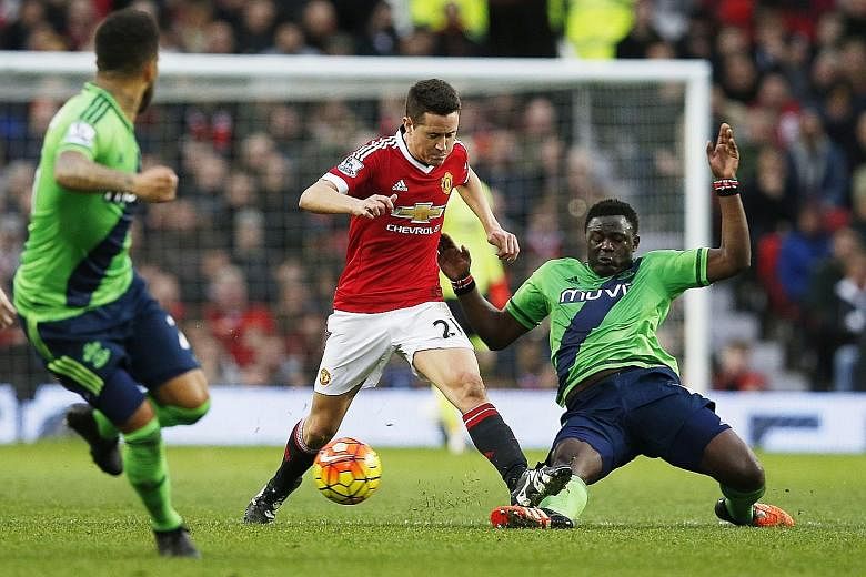 Southampton's Victor Wanyama (right) tackling Manchester United's Ander Herrera during their English Premier League clash at Old Trafford yesterday. An 87th-minute header by new signing Charlie Austin gave the Saints a shock 1-0 victory, and heaped m