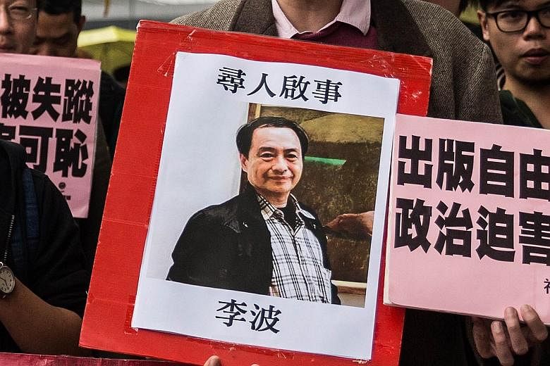 A protester displaying a missing person notice for Mr Lee Bo, the latest of five Hong Kong booksellers from the Mighty Current publishing house to have gone missing. Hong Kong's Sing Tao newspaper published a photo yesterday of Mr Lee and his wife, a