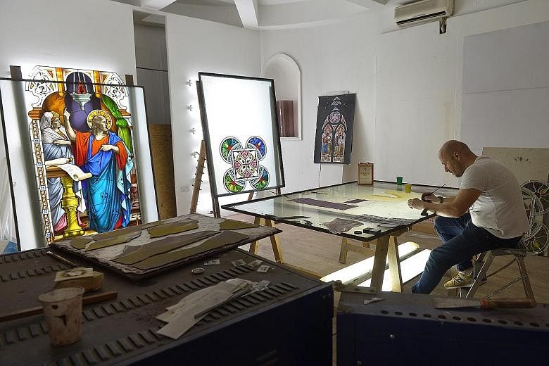 Artisan Ernesto Raducci, 40, at work in Singapore on Friday, carefully beautifying the stained glass that will be installed in the new extension. When Novena Church opens its doors early next year, worshippers can look forward to a new heritage centr