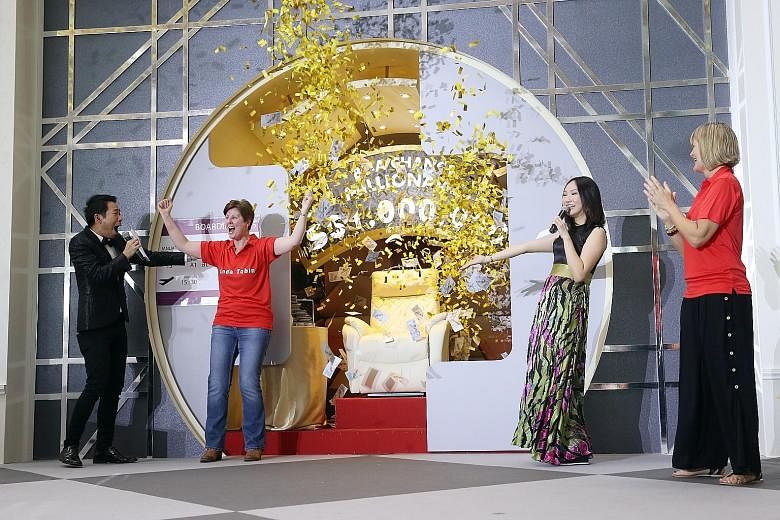 British administrator Linda Tobin, 52, with hosts Chua Enlai (far left) and Lin Peifen, emerging as the winner of a million dollars at Changi Airport. Briton Tracy Tomlinson (left), 52, was the other remaining finalist in the "Be a Changi Millionaire