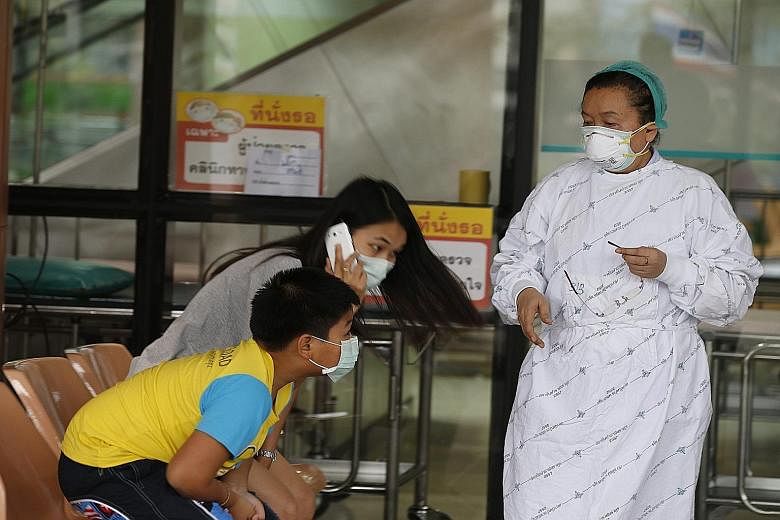 A nurse and visitors wearing masks at the Bamrasnaradura Infectious Diseases Institute on the outskirts of Bangkok yesterday. An elderly Omani who arrived in the Thai capital last Friday has tested positive for the Mers virus.