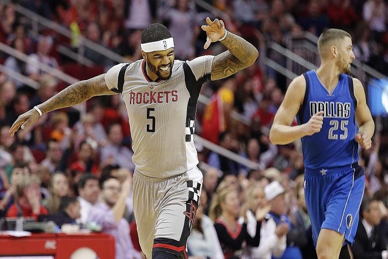Back with Houston after half a season with the LA Clippers, Josh Smith is delighted after making a three-pointer, as Dallas forward Chandler Parsons runs back for the re-start. The Rockets won 115-104.