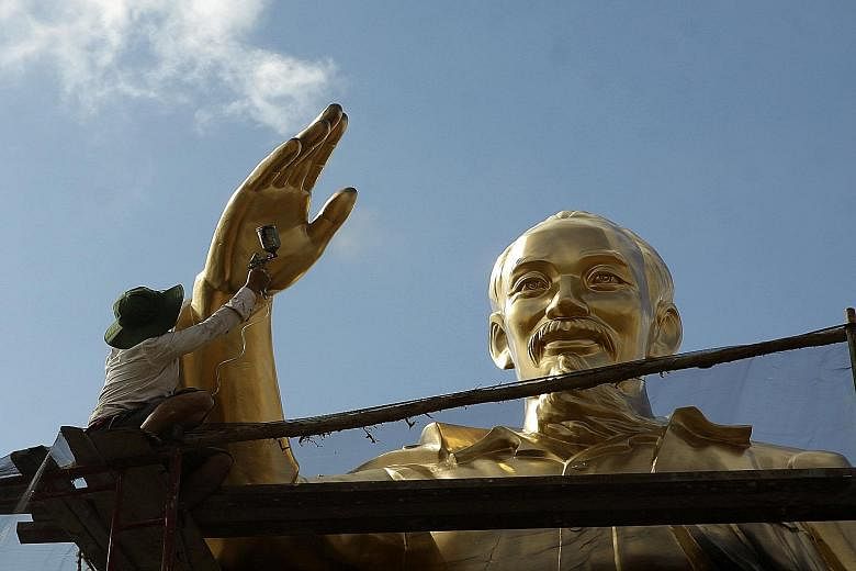A worker repainting a statue of revolutionary leader and founder of modern Vietnam Ho Chi Minh at a park in the southern city of Can Tho. Vietnam began a crucial political transition last week as the five-yearly Communist Party congress convened to p