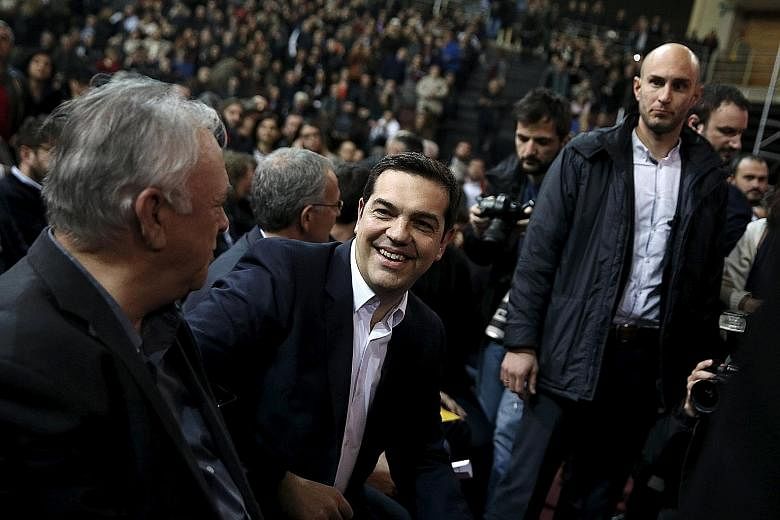 Greek Prime Minister Alexis Tsipras (centre) in a relaxed mood before making a speech to mark his first year in office in Athens. He is headed towards a showdown over Greece's social security reforms, which he wants to push through by raising contrib