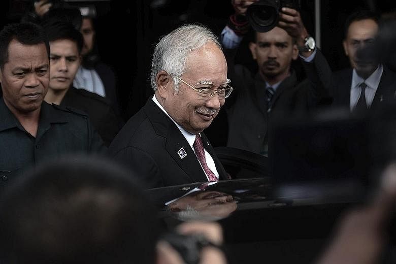 Malaysian Prime Minister Najib Razak (centre) leaving after attending a Parliament session in Kuala Lumpur yesterday. Attorney-General Apandi Ali has cleared Mr Najib of any criminal wrongdoing involving US$681 million donated by the Saudi royal fami
