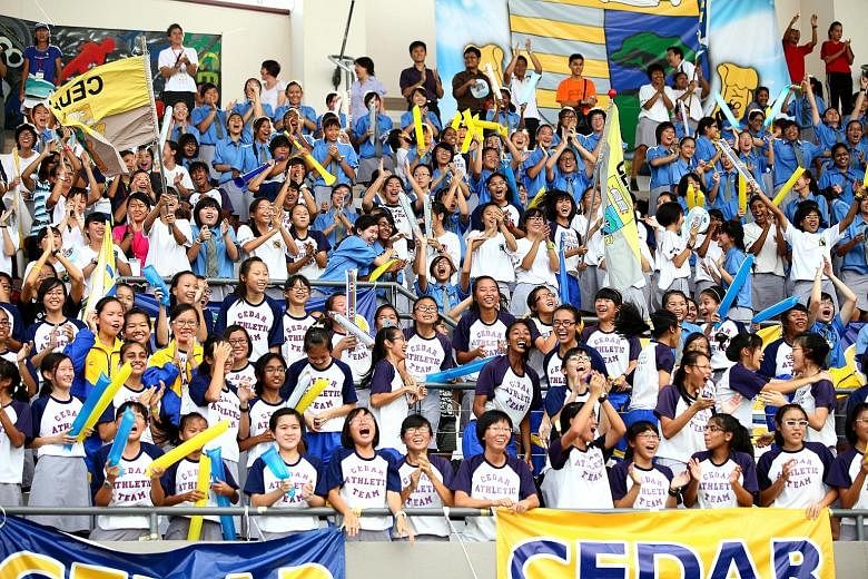 (Left) Supporters cheering during the 52nd Schools National Track and Field Championships at the Choa Chu Kang Stadium in 2011. A similar level of involvement will be seen at this year's schools meet, which is likely to run alongside the Singapore Op