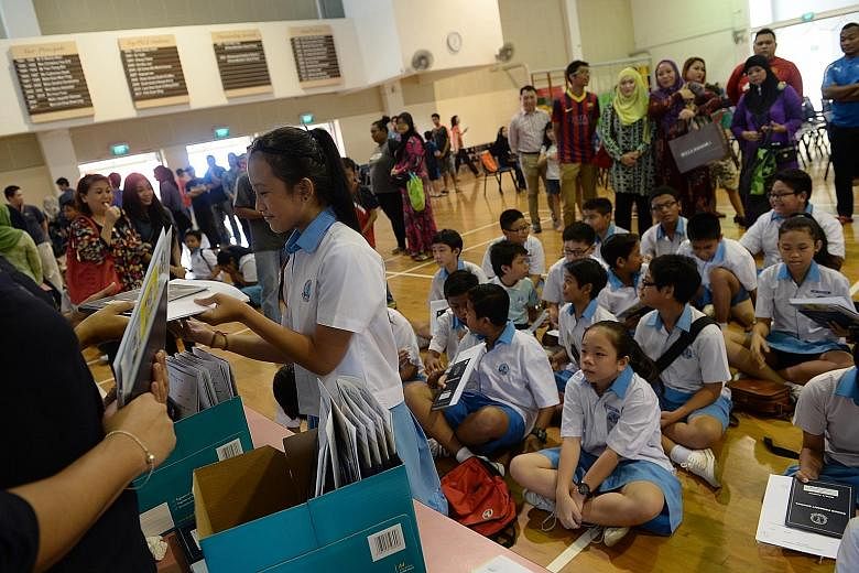 Eunos Primary School pupils receiving their PSLE results last year. Yesterday, Ms Denise Phua renewed her call for the Education Ministry to pilot a 10-year through-train school model - with children moving from the primary to secondary level without