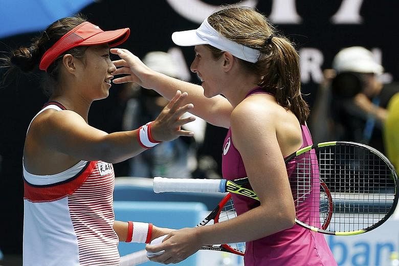 Zhang Shuai (left), the improbable heroine who brought an endearing spark to the women's draw at the Australian Open, embracing Johanna Konta after losing 4-6, 1-6 to the Briton in the quarter-finals yesterday.