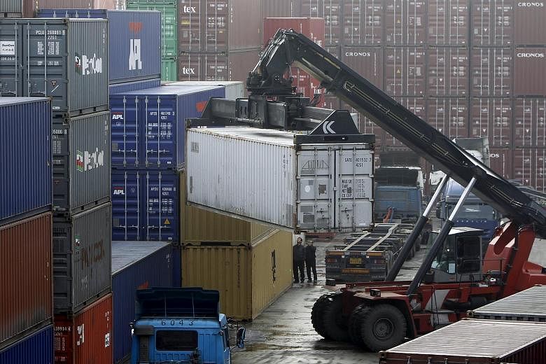 Workers loading trucks with containers at a terminal of an Inland Container Depot in Uiwang, south of Seoul.