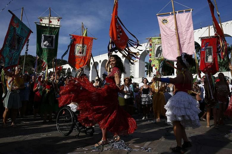 Revellers in costume participate in the bloco (street band) Cordao do Boitata parade in Rio de Janeiro.