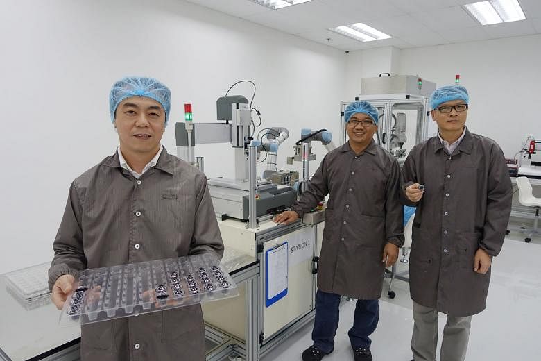 Mr Chee (left), Moveon Technologies' chief executive, with engineers Randy Hipona (centre) and Xie Jie Lin, who have been seconded from A*Star to help boost the company's R&D processes since 2014. The optical solutions firm spends almost $2 million a year
