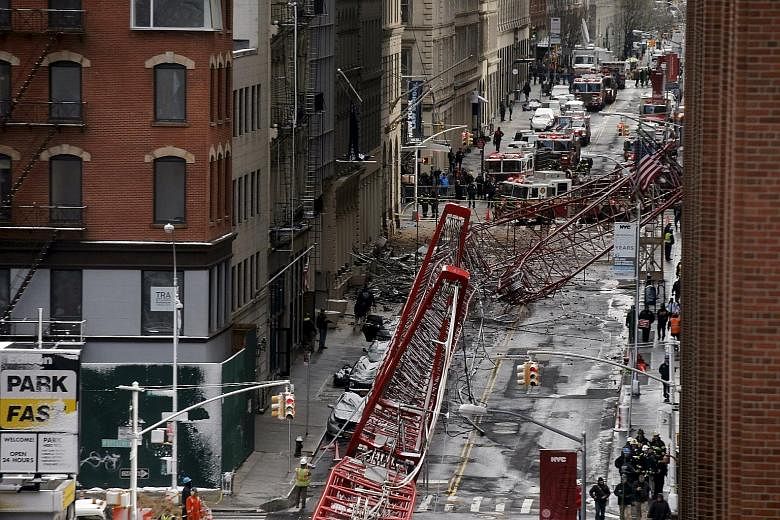 Emergency responders at the site where a 172m-tall crane toppled, stretching along nearly two city blocks in downtown Manhattan, in New York City, on Friday. The massive construction crane collapsed during a swirling snowstormin the morning. Manhatta