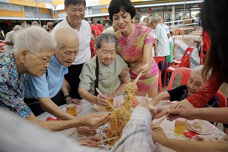 Residents (from far left) Madam Ee Goh Neo, 87, and her husband, Mr Choe Seong Phan, 97, Madam Wan Law Lui, 90, and Madam Choong Keng Chan, 101, doing a lo hei with Ms Joan Pereira (in floral cheongsam), an MP for Tanjong Pagar GRC, and Henderson-Daw