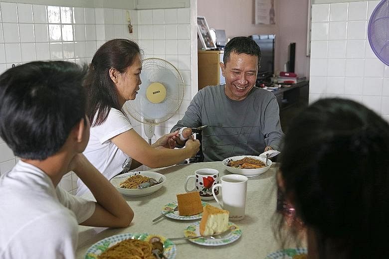 Madam Choong Siet May helping her husband, Mr Tan Whee Boon, to adjust a strap around his arm so that he can hold on to utensils and have lunch with his two teenage children. Mr Tan had four amputations last year after a bout of GBS infection, follow