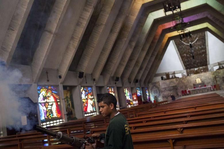 A worker fumigates a church to eradicate the mosquitoes that cause the Zika virus in Caracas, Venezuela. 