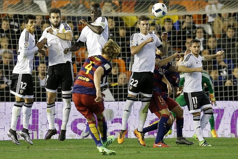 Barcelona midfielder Ivan Rakitic (No. 4) taking a free kick against Valencia during the King's Cup semi-final on Wednesday. Barcelona earned a late 1-1 draw for an 8-1 aggregate win, taking them to a fifth final in six years.