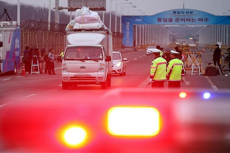 A lorry leaving the Kaesong industrial zone in North Korea and passing a military checkpoint in Paju, South Korea, yesterday. Pyongyang called Seoul's decision to suspend operations at the park a "declaration of war", while South Korean firms slammed