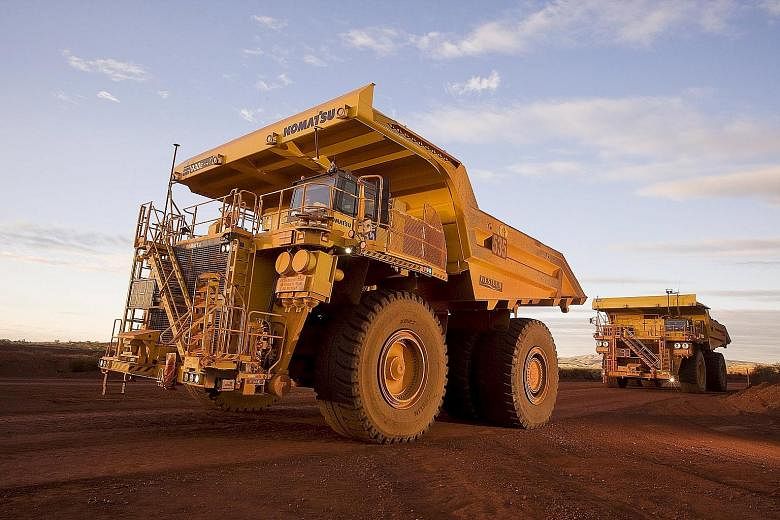 Giant haulage trucks at an iron ore mine in the Pilbara area of Western Australia in this photo provided by Rio Tinto. The company reported that underlying earnings fell to US$4.5 billion last year, from US$9.3 billion a year earlier.