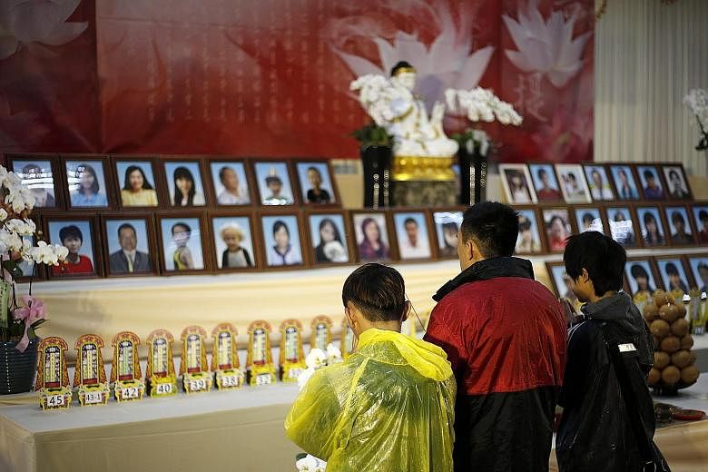 Relatives attending a memorial service for quake victims in Tainan yesterday. The 6.4-magnitude quake has left at least 96 people dead, and 94 of them were residents of a building that collapsed.