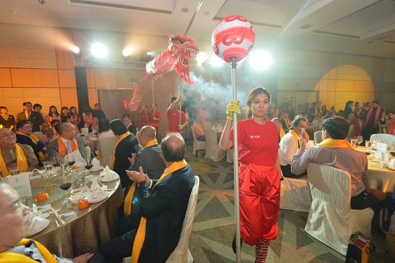 Ms Joey Kirk, vice-president of enterprise banking at United Overseas Bank (UOB) Group, led senior staff in a dragon dance for charity as UOB Group deputy chairman and chief executive officer Wee Ee Cheong (seated second from left, with pink tie) looked o