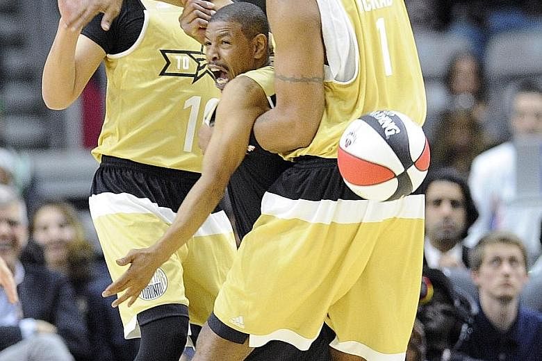 Canada player Kris Wu (10) looks on as team-mate Tracy McGrady (right) fouls USA player Muggsy Bogues (1.6m) during the All-Star celebrity game. The All-Star weekend is being held in Canada for the first time.