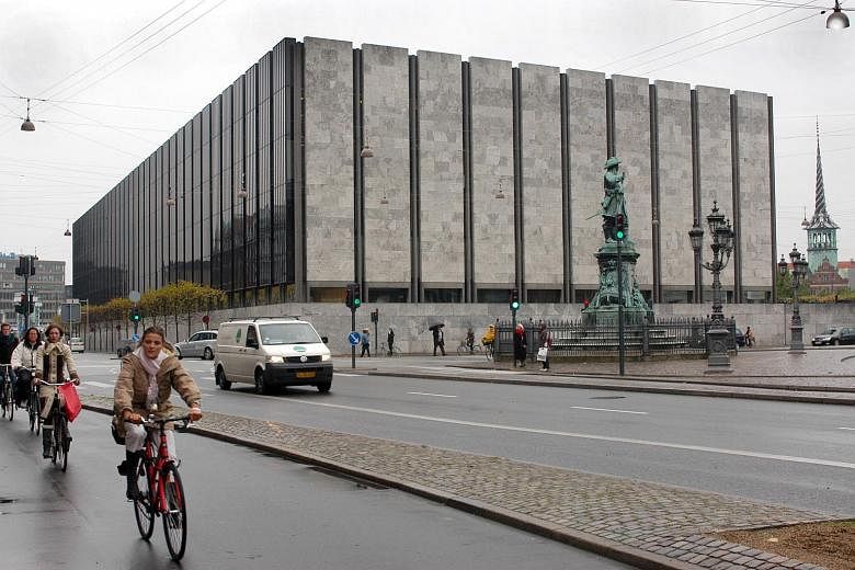 Cyclists ride past Denmark's central bank in Copenhagen.