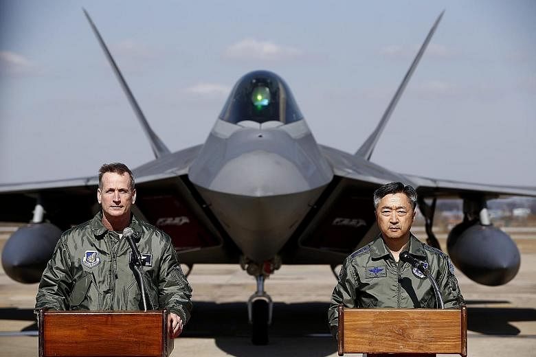Lt-Gen O'Shaughnessy (left) of the US Air Force and South Korean Air Force operations commander Lee Wang Geun in front of an F-22 stealth fighter during a press briefing at Osan Air Base yesterday.