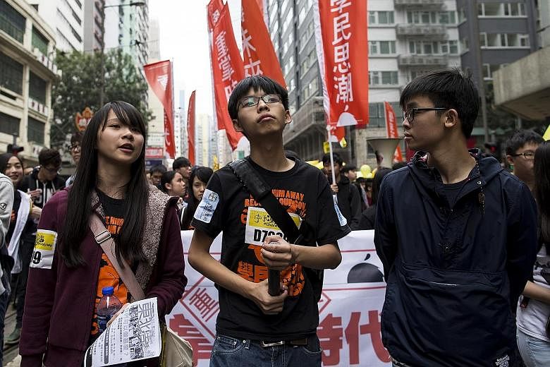 Hong Kong student leaders (from left) Agnes Chow, Joshua Wong and Oscar Lai marching to demand universal suffrage during a rally last year. Mr Lai, 21, and several other members of the student activist group Scholarism will run in local legislative p