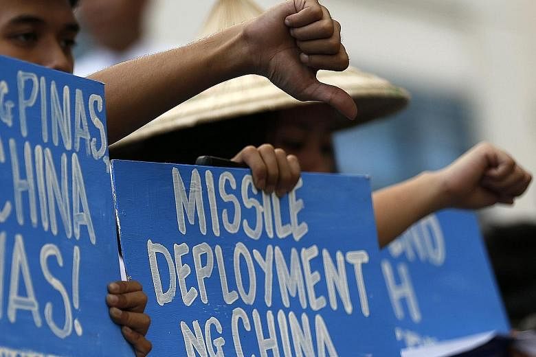People staging a demonstration yesterday at the Chinese consular office in Makati city, south of Manila, to protest against China's apparent deployment of a surface-to-air missile system on Woody Island in the South China Sea. While Chinese officials