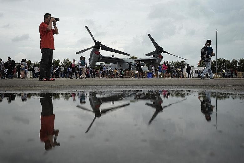 A queue (left) forms as visitors wait for a chance to sit in the cockpit of an F-15SG from the Republic of Singapore Air Force, probably the closest they will ever get to such a fierce fighter. It is not all strictly a display of macho military might