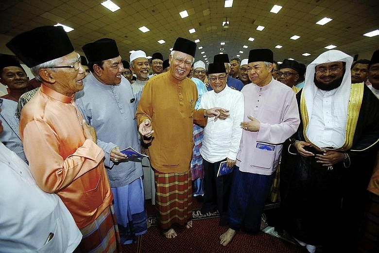 Malaysian Premier and Umno president Najib Razak (centre) was joined by other party members and guests including his deputy Ahmad Zahid Hamidi (second from right) and Sheikh Mohd Idris Mohd Al-Mashrafi, an imam from Mecca in Saudi Arabia (right), at 