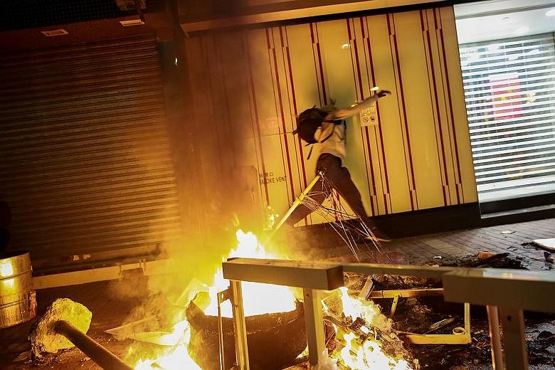 A rioter throwing an object during the violent Mongkok protest on Feb 9. In the worst conflict in Hong Kong since riots in the 1960s, protesters prised bricks from pavements to hurl at the police and set fire to bins and even a taxi. About 130 people