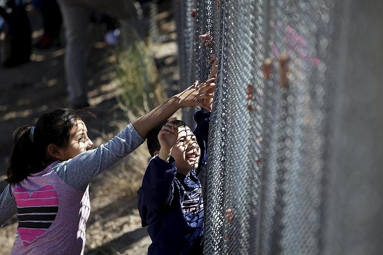 Children touching the hands of a family member through the border fence between Ciudad Juarez and El Paso, United States, after a Mass in support of migrants in Ciudad Juarez, Mexico, this month. There are now more Mexicans leaving the US than going 