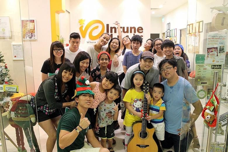 A rehearsal held at Intune Music School in December involving instructors, students, parents and members of NTUC's youth group nEbO. The school has an annual revenue of between $700,000 and $800,000. Mr Lim (foreground, left with hat), its founder an