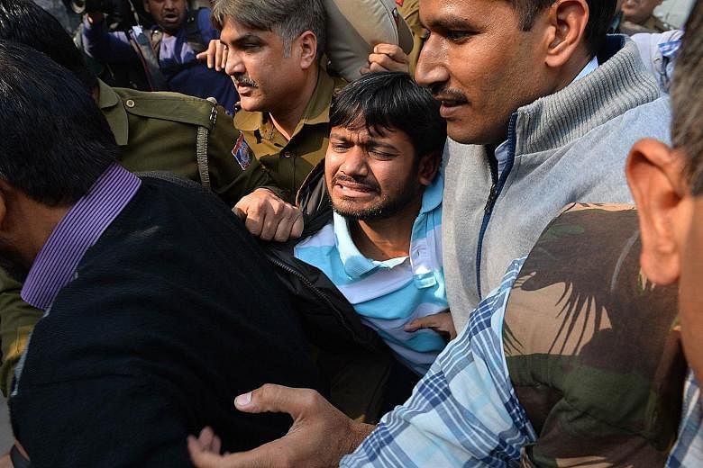 Police escorting student union leader Kanhaiya Kumar (centre) to a court in Delhi last Wednesday. The five students who emerged from hiding yesterday were wanted since the arrest of Kumar.