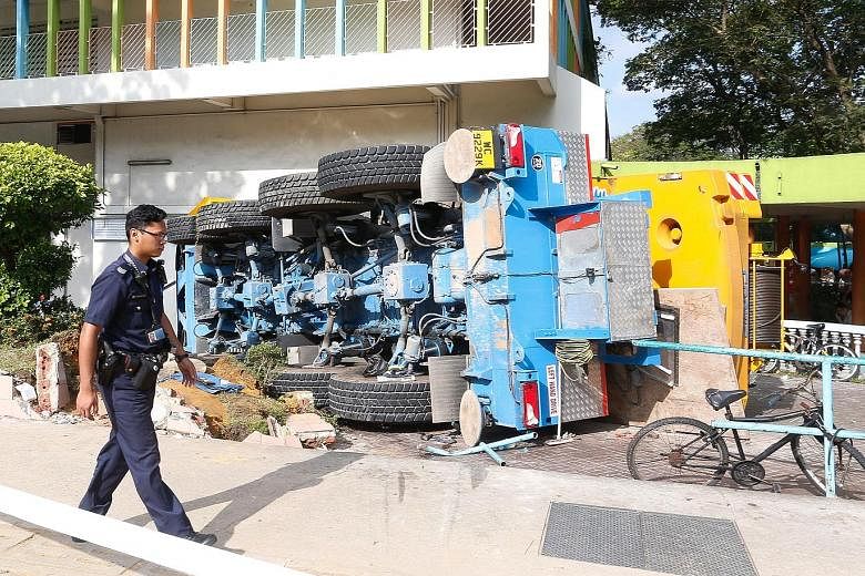 The mobile crane crash (above and left) yesterday morning left a roughly 2m-wide hole in the wall of the POSB bank branch on the ground floor of Block 2A in Woodlands Town Centre. Eyewitnesses said that the driver of the crane escaped unhurt with the