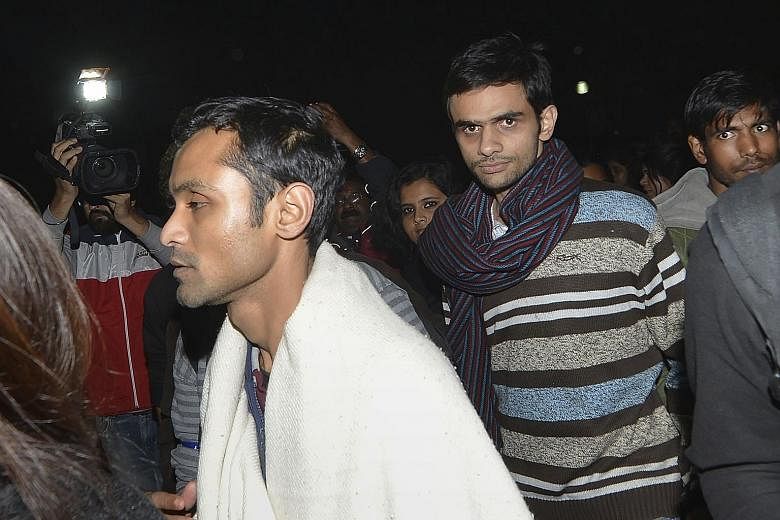 Indian student activists Umar Khalid (with striped scarf) and Anirban Bhattacharya (with white shawl) walking across the campus of New Delhi's Jawaharlal Nehru University on their way to surrendering to the Indian authorities on Tuesday.
