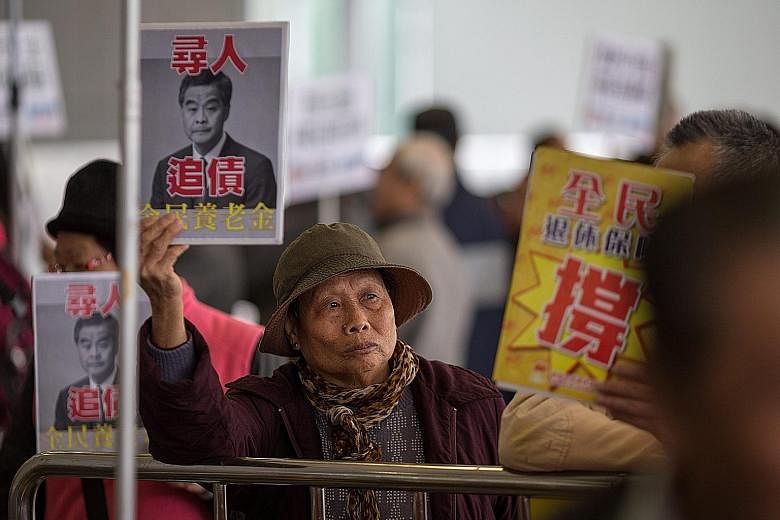 Protesters demanding universal pensions outside the Legislative Council before the annual budget announcement in Hong Kong yesterday. Financial Secretary John Tsang expects Hong Kong's economy to grow just 1 per cent to 2 per cent this year on the ba