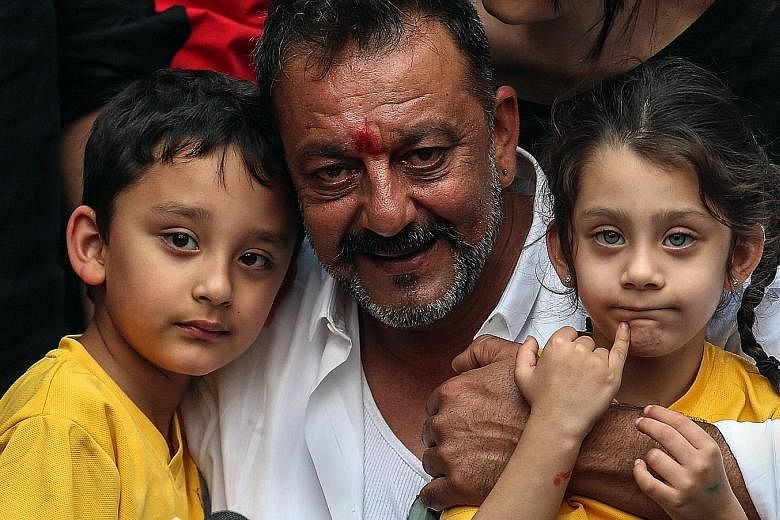 Mr Dutt hugging his twins Shahraan (far left) and Iqra. He was jailed for possessing an automatic rifle and a pistol that were part of a cache of weapons brought to Mumbai before the 1993 bombings which killed 257 people.