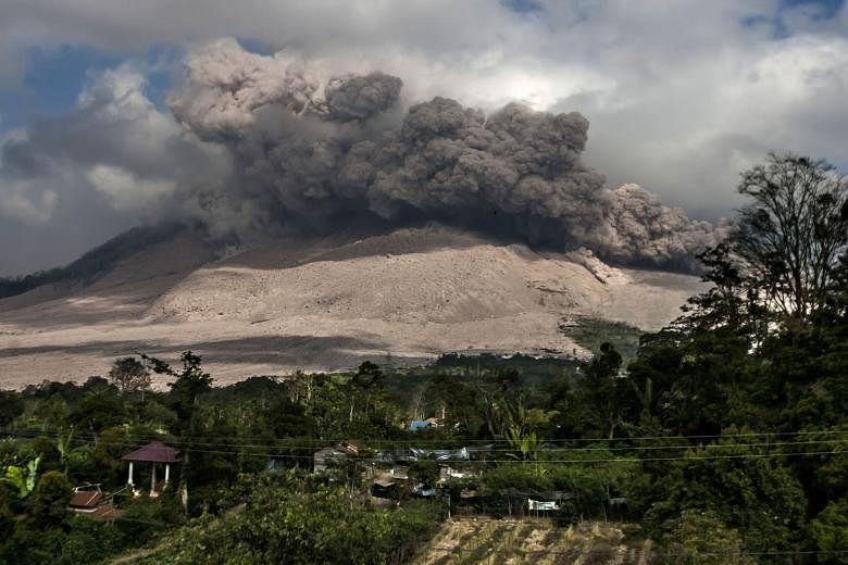Mount Sinabung spewing volcanic ash, seen from Gamber village in Karo district, in North Sumatra yesterday. It is one of 129 active volcanoes in Indonesia. The country sits on the Pacific Ring of Fire, a belt of seismic activity running around the basin o