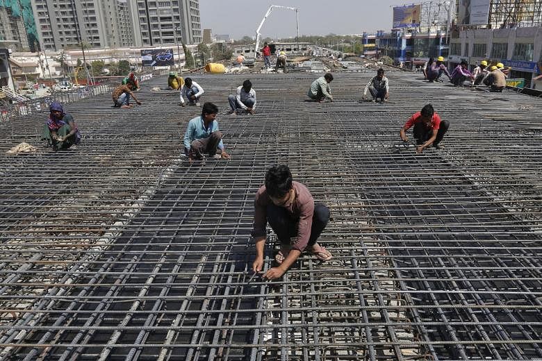 Workers at a flyover construction site on the outskirts of Ahmedabad in western India. Prime Minister Narendra Modi has made economic growth a priority, but investors have raised concerns about the pace of reform. 