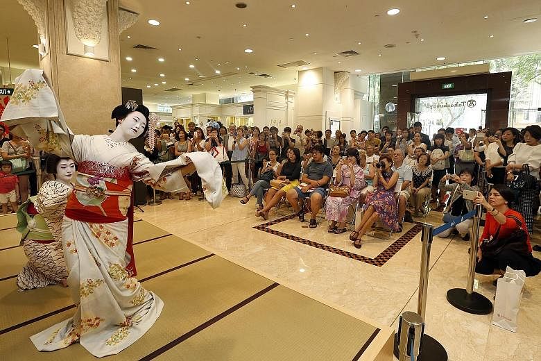 Performers from Kyoto doing a traditional duet dance for shoppers at Takashimaya department store yesterday, as part of the Kyoto Sakura celebration. The dancers are known as geiko (far left) and maiko - as geishas are known in Kyoto. The maiko is an