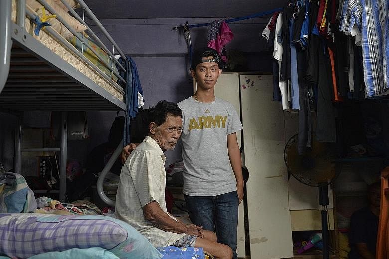Mr Md Ridzwan Azmi with his grandfather, Mr Ahmad Taman, who was working as a security guard until earlier this month, when he was diagnosed with lung cancer after a fall at work.