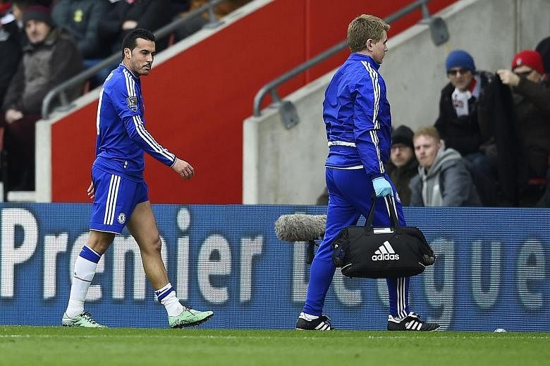 Pedro (left) leaving the pitch with a hamstring injury on Saturday. Chelsea interim manager Guus Hiddink believes such injuries to his players are caused by a fixture overload.