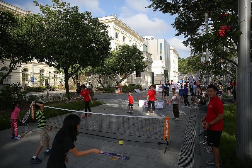 Participants enjoying a modified version of tennis in front of the Victoria Theatre and Concert Hall yesterday morning. They were also able to try out modified versions of sports such as basketball and football. A piloxing fitness party at the Empres