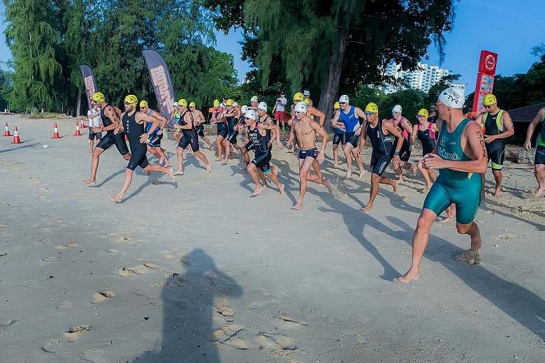 Two-time Ironman world champion Chris McCormack (in green suit) joining 46 participants for an aquathlon race to finish off a three-day training camp at East Coast Park yesterday. McCormack was in town to launch the TRI-Factor triathlon series.